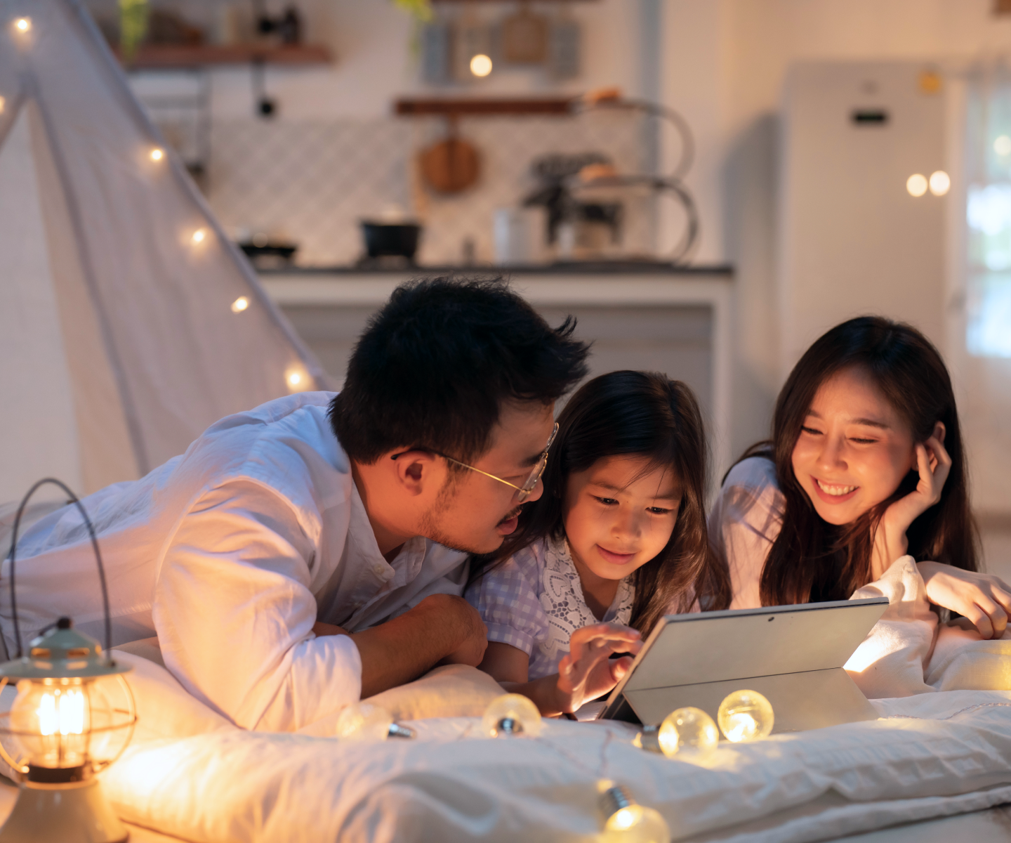 Dad and two daughters watching on a tablet.