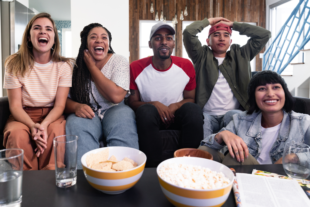 Group of friends watching YouTube TV with popcorn and chips.