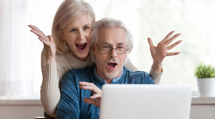 A couple is happy while using their computer