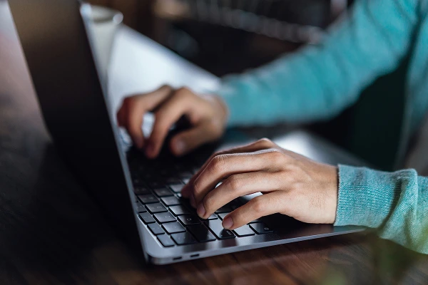 A person typing on a laptop