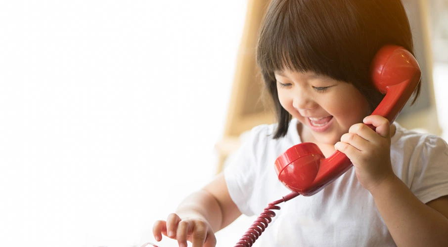 Little girl using landline home phone