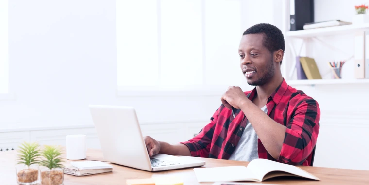 Man sits at desk with a laptop