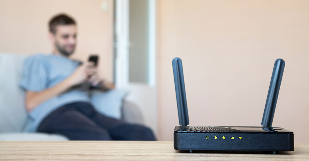  router sending wifi to man using internet on mobile device