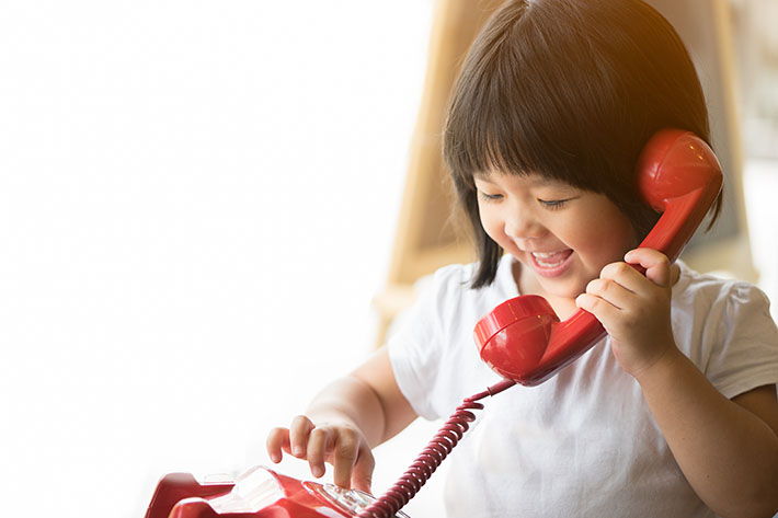 little girl using landline home phone